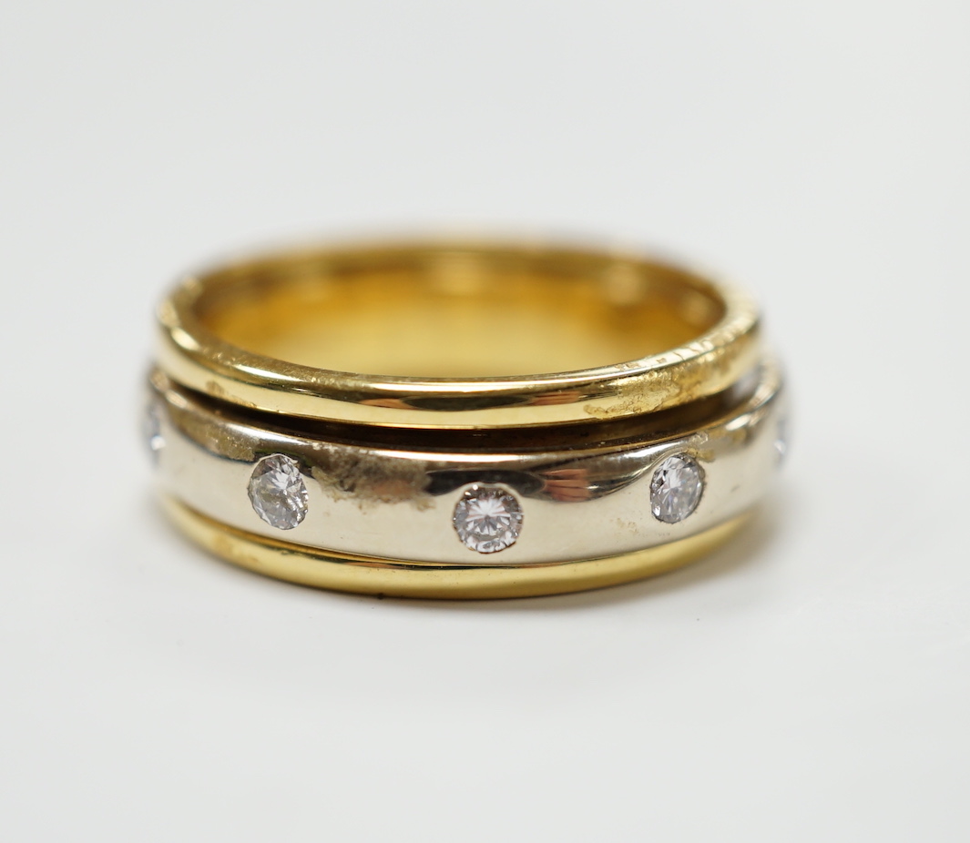 A modern 750 yellow metal ring, with central diamond set rotating white metal band (stone missing), size P/Q, gross weight 7.9 grams.